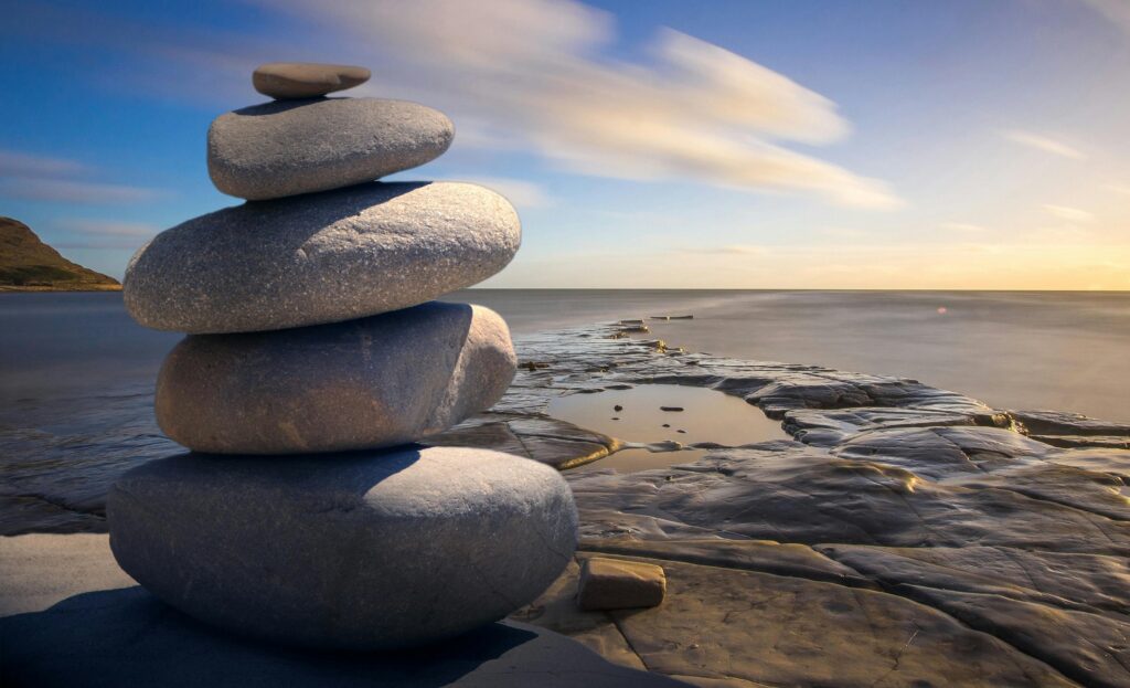 pexels-photo-289586-289586 A serene stack of stones on the rocky seashore during a peaceful sunrise, embodying balance and zen.